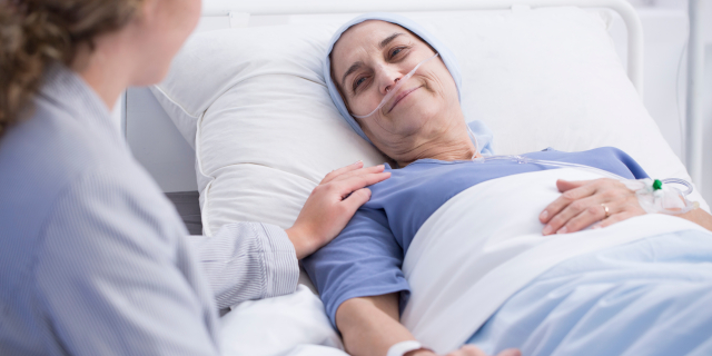 Mujer mayor sonriente con un tumor y una enfermera encargada en el centro de salud